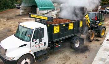 white truck being loaded with topsoil