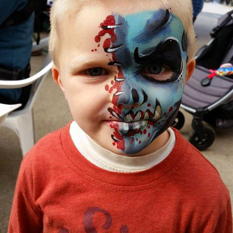 Boy with half face painted like monster