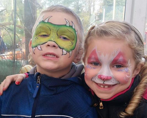 boy and girl with face painted one like monster other white and red